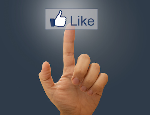 Image of a human finger clicking the Facebook like button.