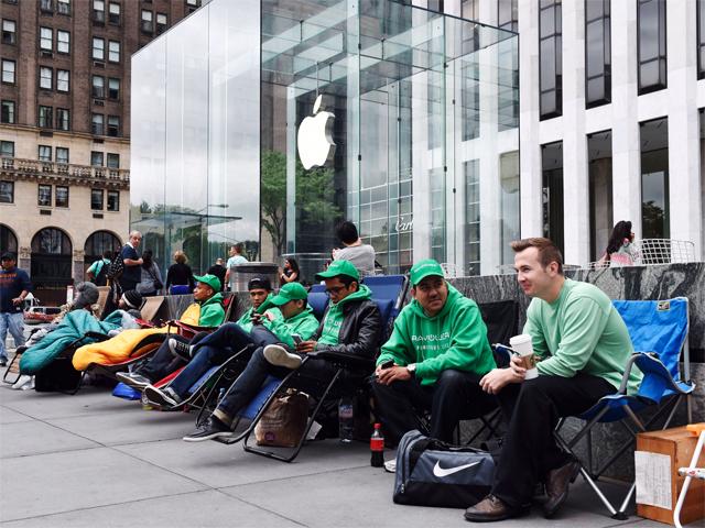 Image of people waiting outside of an Apple store for a product release.