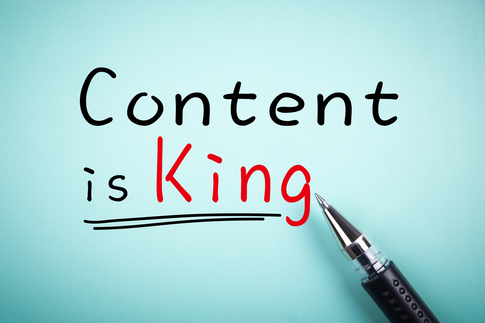 Image of pen writing the words content is king. 