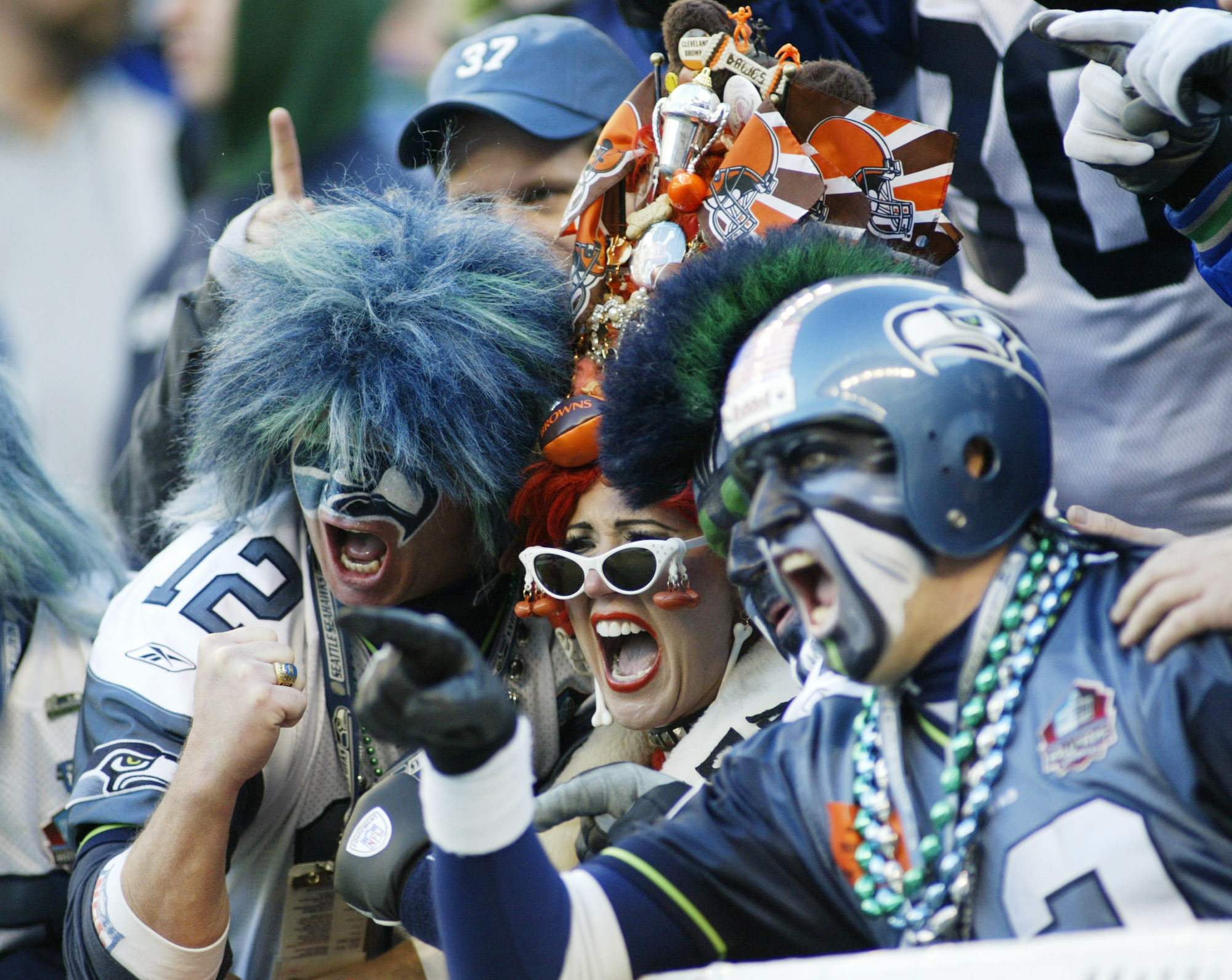Seattle Seahawks fans surround a Cleveland Browns fan as she mugs for TV cameras Sunday, Nov. 30, 2003 at Seahawks Stadium in Seattle. (AP Photo/Ted S. Warren)
