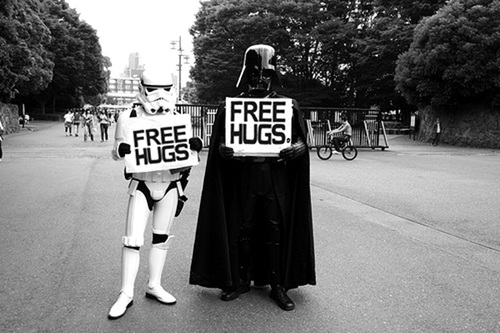 Image of a storm trooper and Darth Vader from Star Wars holding "free hugs" signs.