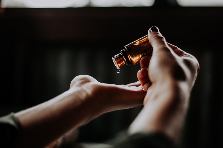 Image of massage therapist putting massage oil on their hands.