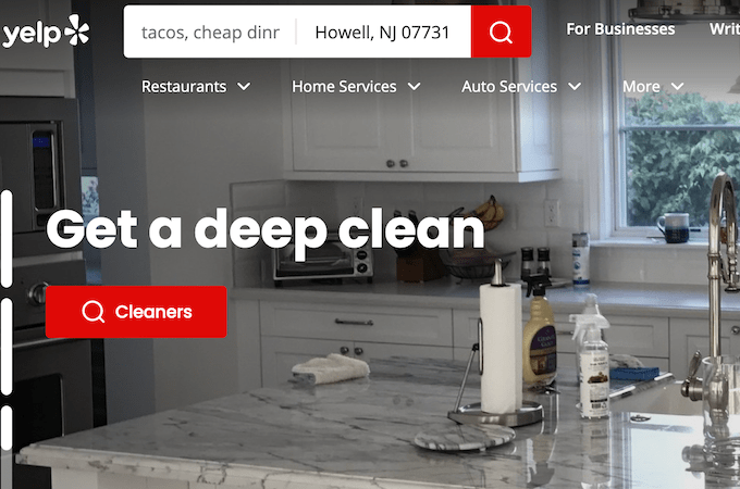 A screenshot of the Yelp home page featuring a clean countertop with cleaning supplies.